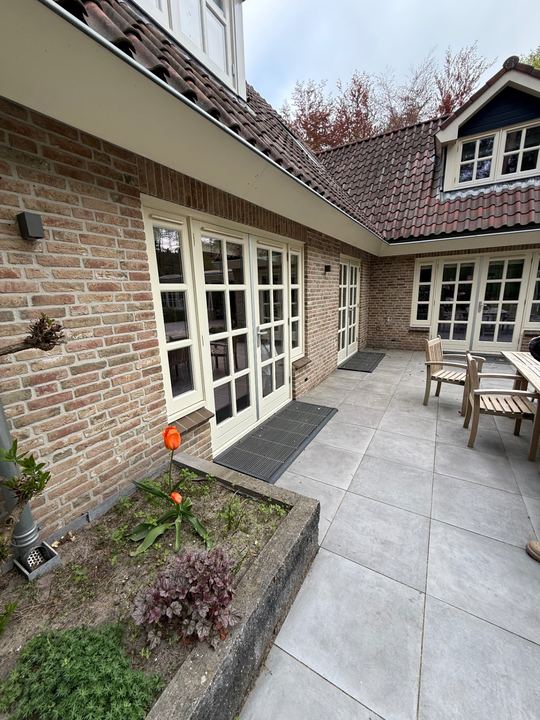Witte glazen deuren en ramen aan de achterzijde van een woning